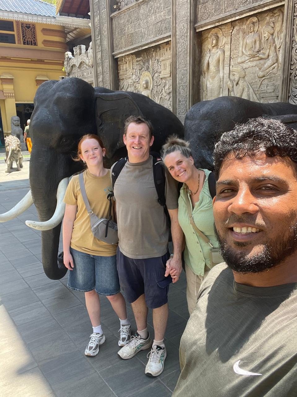 Family visiting elephant statues at Gangaramaya Temple in Colombo